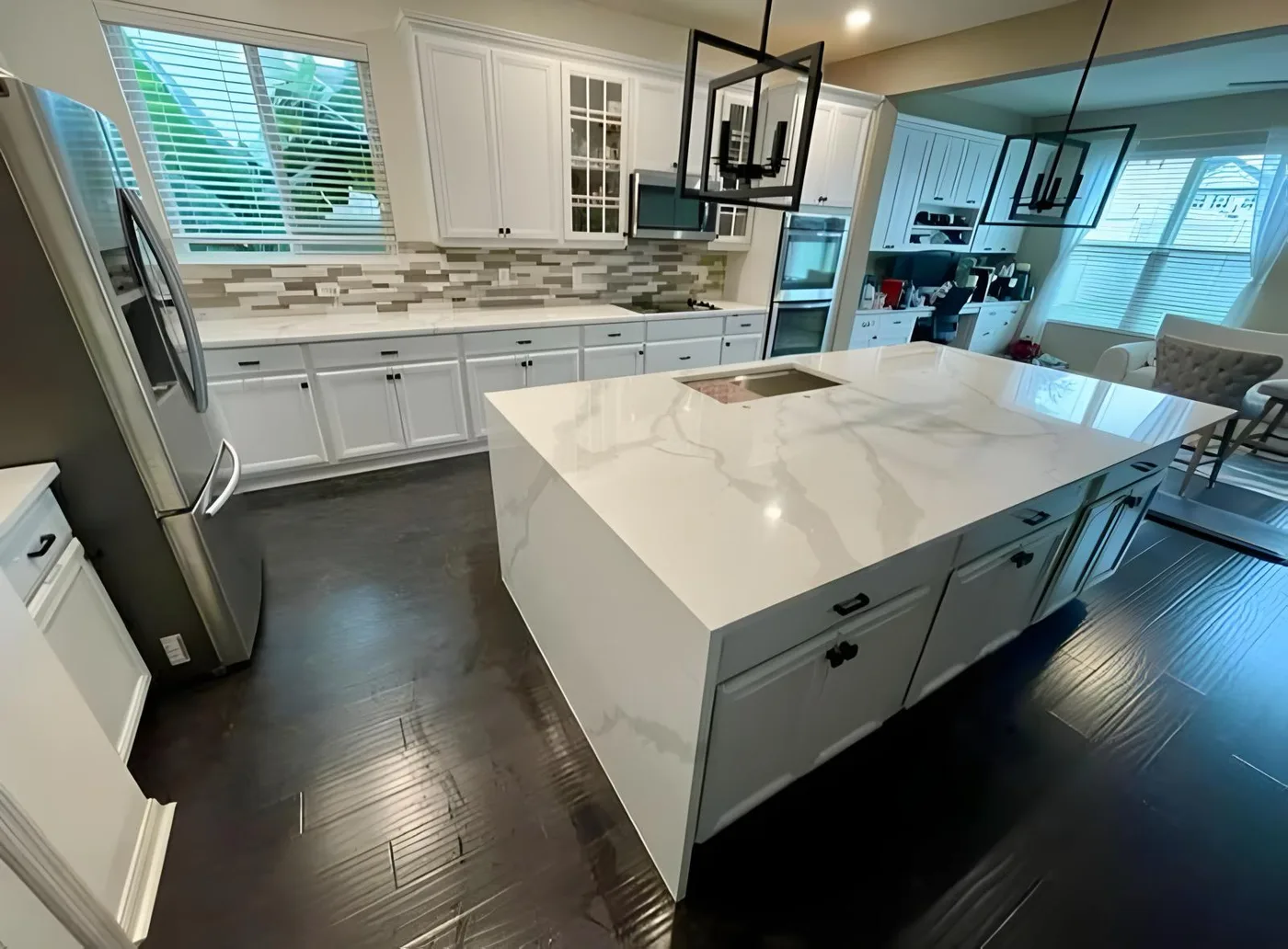 Kitchen island with a stone top and a waterfall panel running to the floor