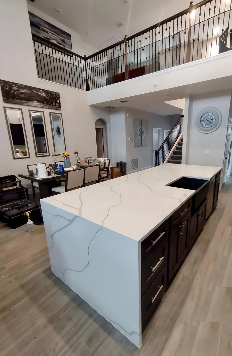 Two story kitchen with a long island and a waterfall edge