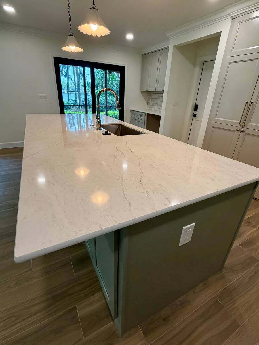 Kitchen island with a green painted base and a white stone top