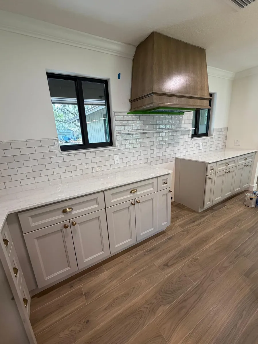 Kitchen with a wood range hood and light stone countertops
