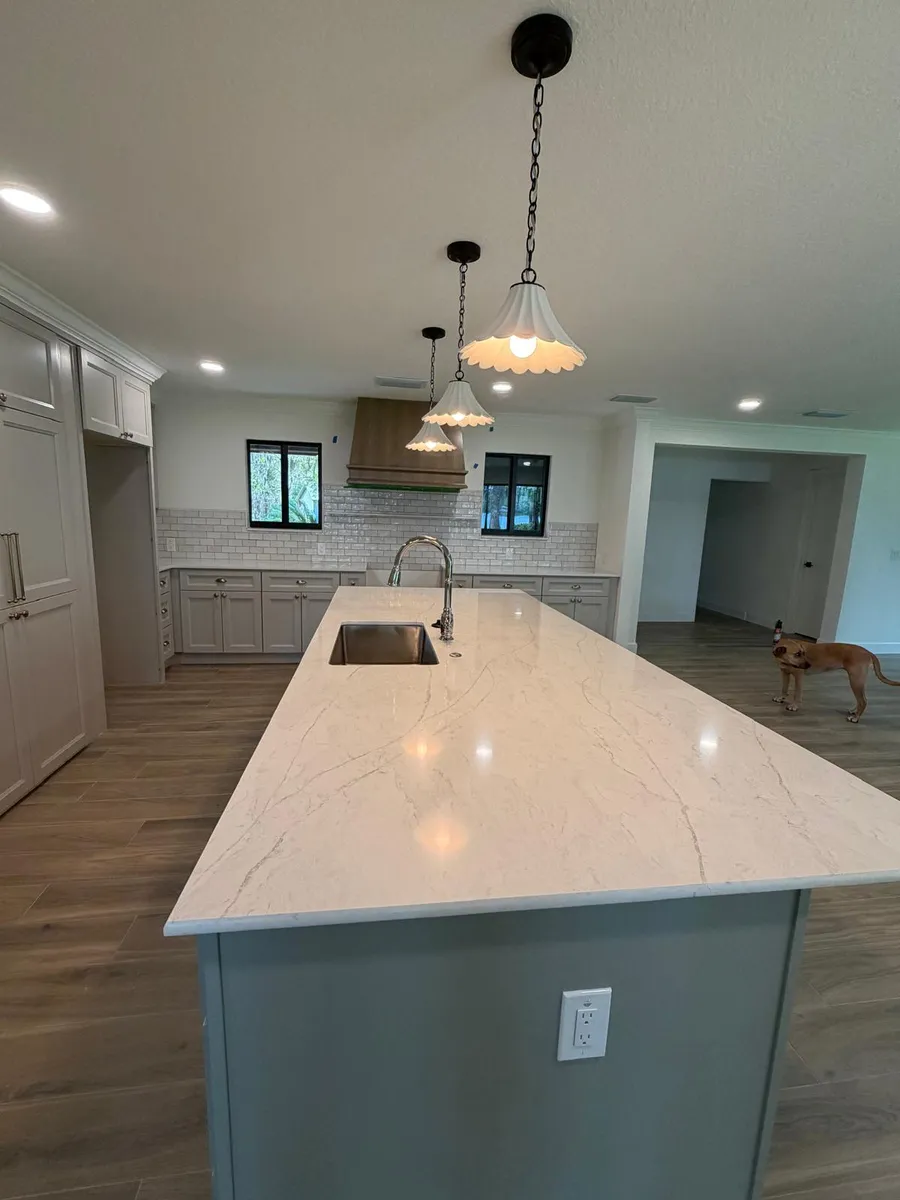 Large island with a light engineered stone top and an undermount sink