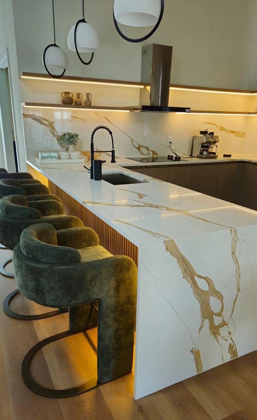 Kitchen island with a veined engineered stone top and bar seating